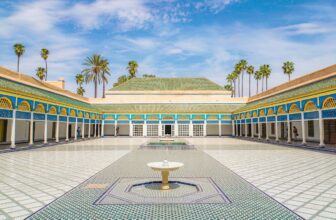 Bahia Palace courtyard with zellij tiles, marble fountain, and colorful arches in Marrakech, Morocco