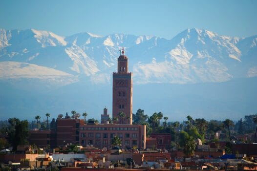 Koutoubia Mosque standing before the snow-capped Atlas Mountains in Marrakech, Morocco