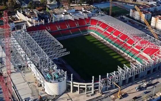 Aerial view of Rabat’s Prince Moulay El Hassan Stadium under renovation, showing cranes and construction work around the red and green seating area