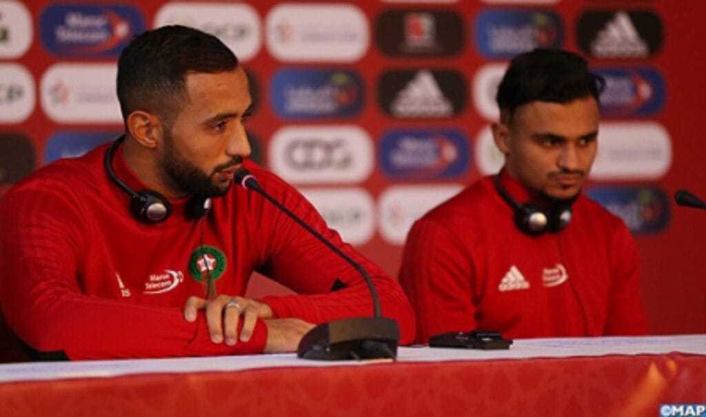 Mehdi Benatia speaking at a press conference for Morocco’s national football team, wearing the red Atlas Lions kit — © MAP.