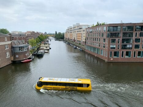 Yellow amphibious tourist bus navigating a city canal, representing Rabat’s upcoming Bouregreg River project