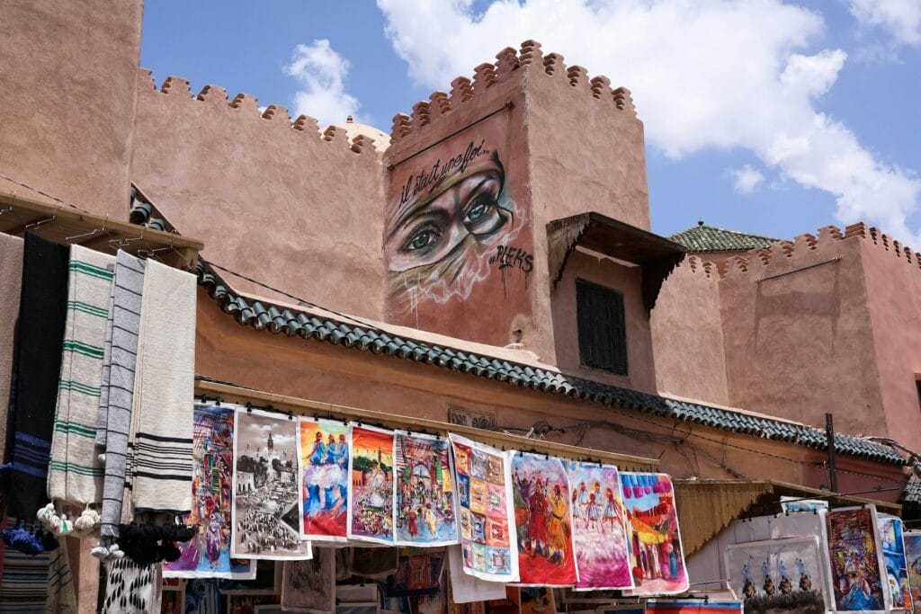Mural of eyes painted on a pink wall above a market in Marrakech Medina, Morocco