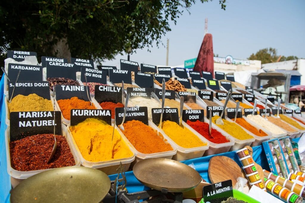A colorful assortment of Moroccan spices arranged in open containers at a traditional souk market.