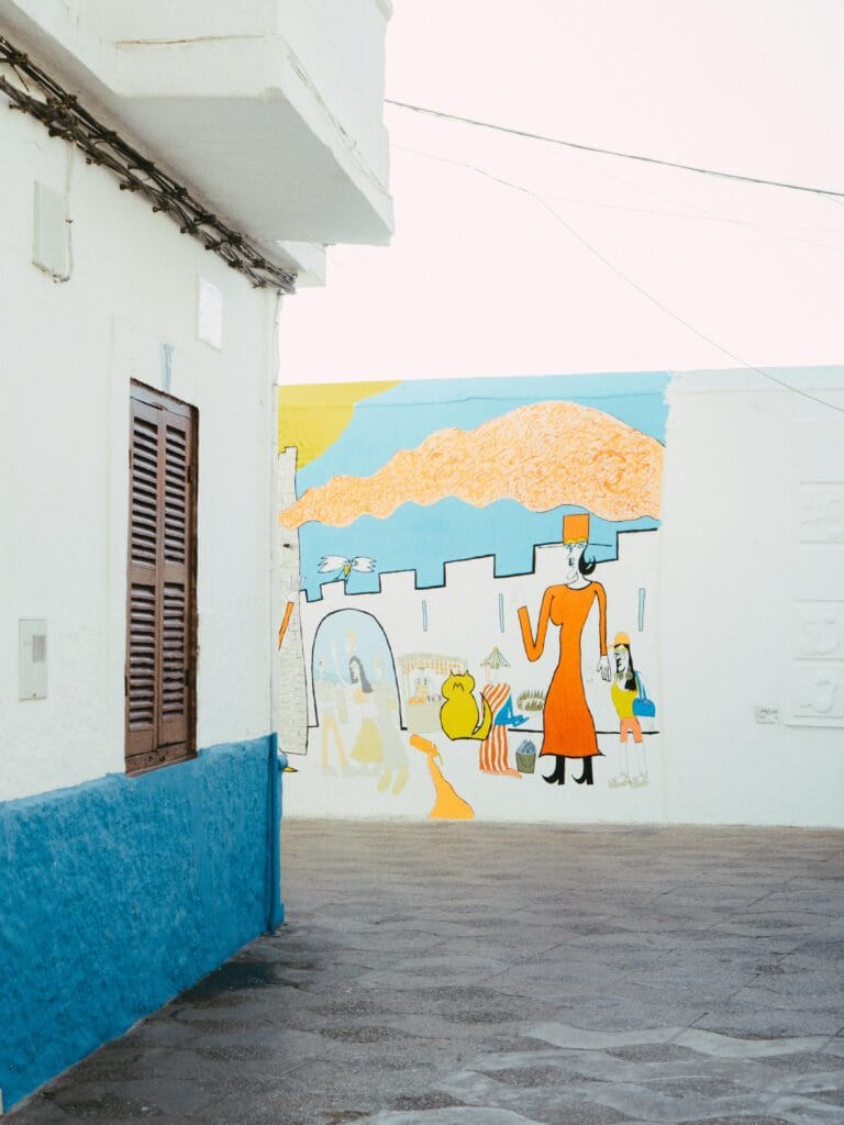 Artists paint murals on the town’s white walls. By Karim Ouakkah / Pexels 