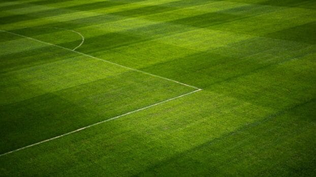Well-maintained football pitch with visible line markings and green turf, representing stadium preparation for AFCON 2025 in Morocco.