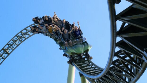 Visitors enjoying a roller coaster ride at a modern theme park, illustrating the global attractions and leisure industry.
