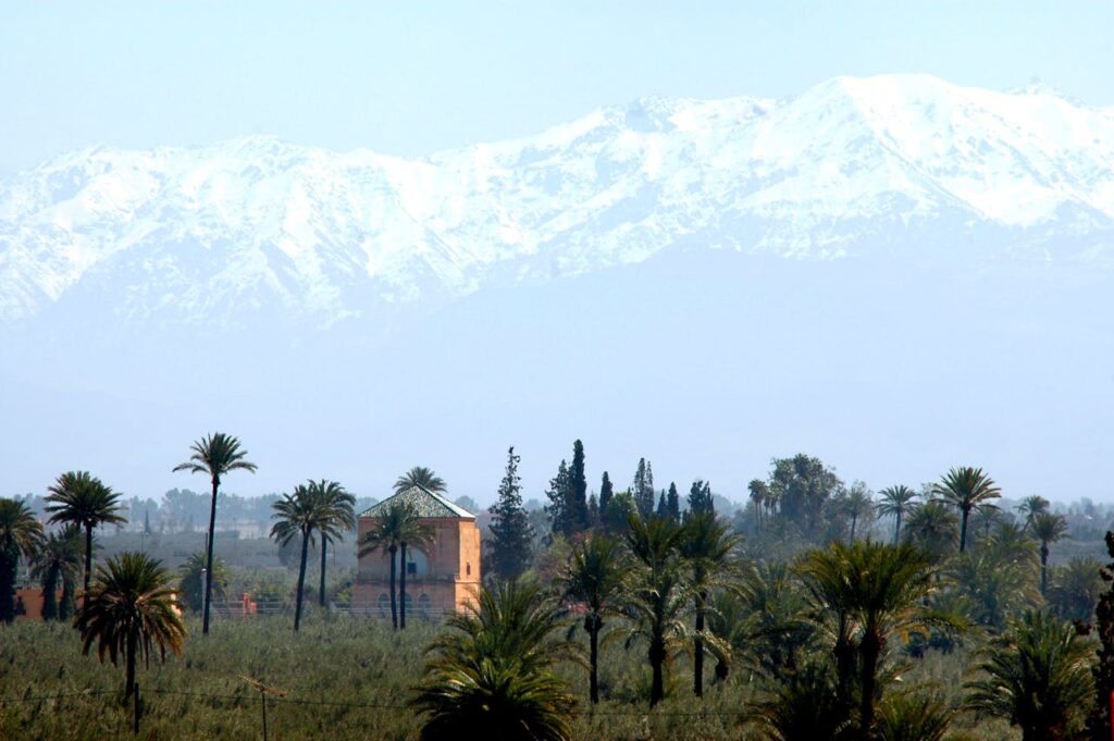 Snow-covered Atlas Mountains overlooking palm groves in Morocco during winter