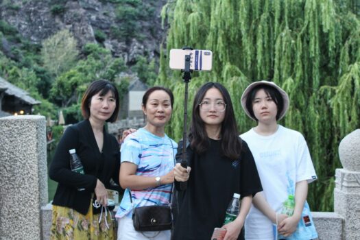 Group of Chinese tourists taking photos at a scenic location in Morocco during a year of strong tourism growth.
