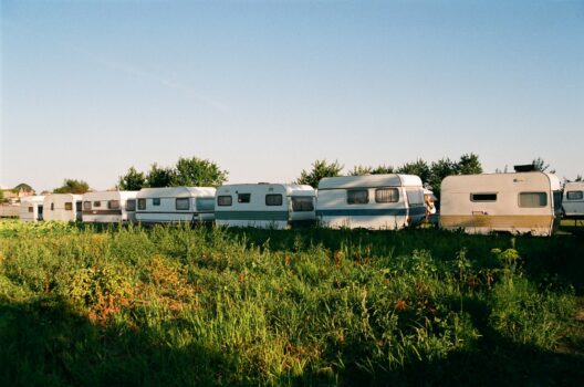 Row of camper vans parked in a grassy field illustrating rising European camper tourism in Morocco.