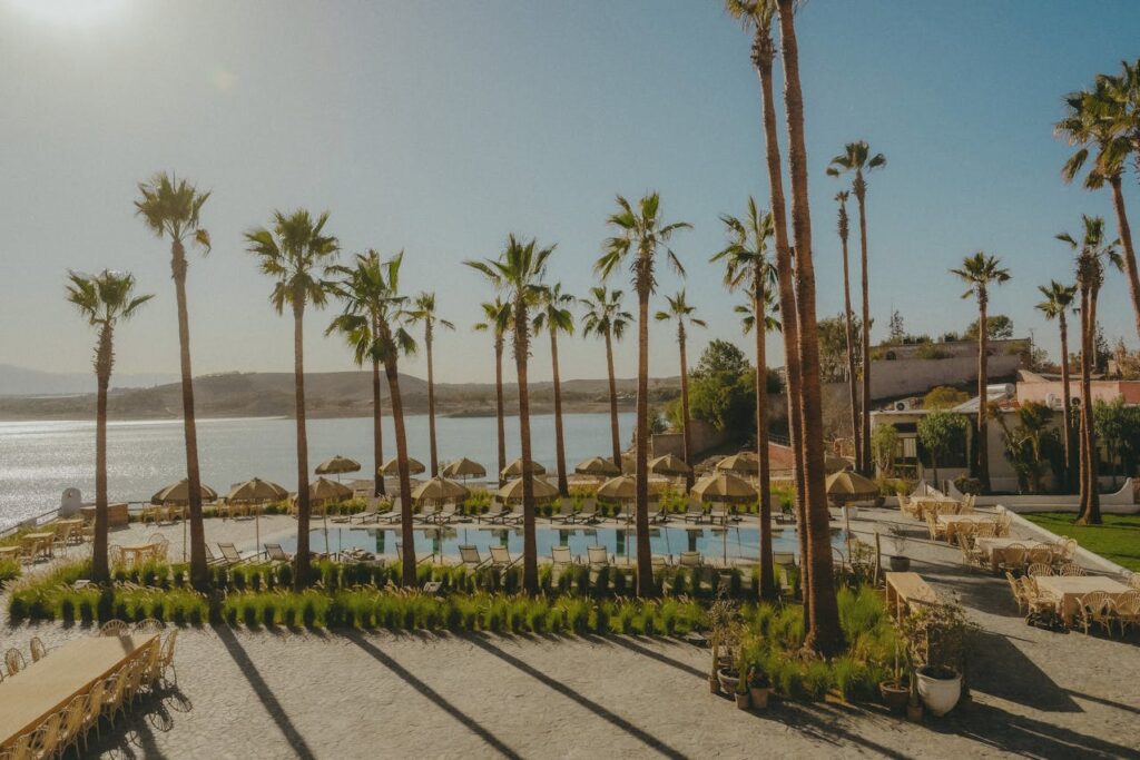 Lalla Takerkoust Lake near Marrakech with palm trees, pool terrace, and Atlas foothills in the background